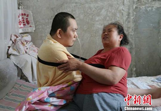 身體日漸衰老的梁青蘭每次幫兒子翻身、坐立，全身的衣物都要濕透一次?！∩忻鱾b 攝