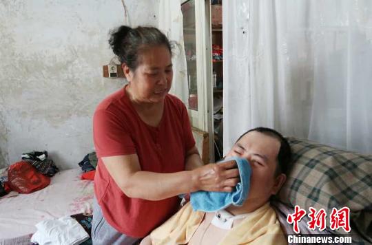 每次喂完食物后，梁青蘭都要仔細(xì)地幫兒子清理干凈?！∩忻鱾b 攝