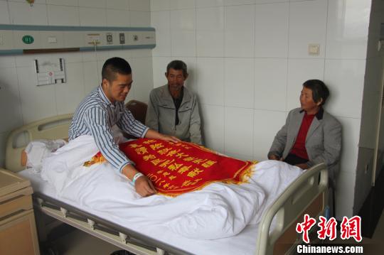 被救的李忠起、張總鳳夫婦看望受傷后的李運(yùn)飛。　汪渝 攝