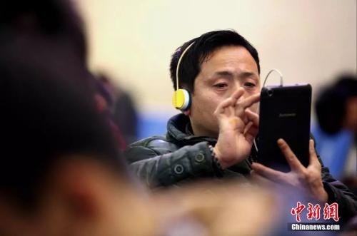 資料圖：候車室內(nèi)，玩手機(jī)的&ldquo;低頭族&rdquo;隨處可見。刷微博、聊微信、玩游戲、看電影，高科技將大多旅客變?yōu)槭謾C(jī)&ldquo;低頭族&rdquo;。<a target='_blank' ><p  align=