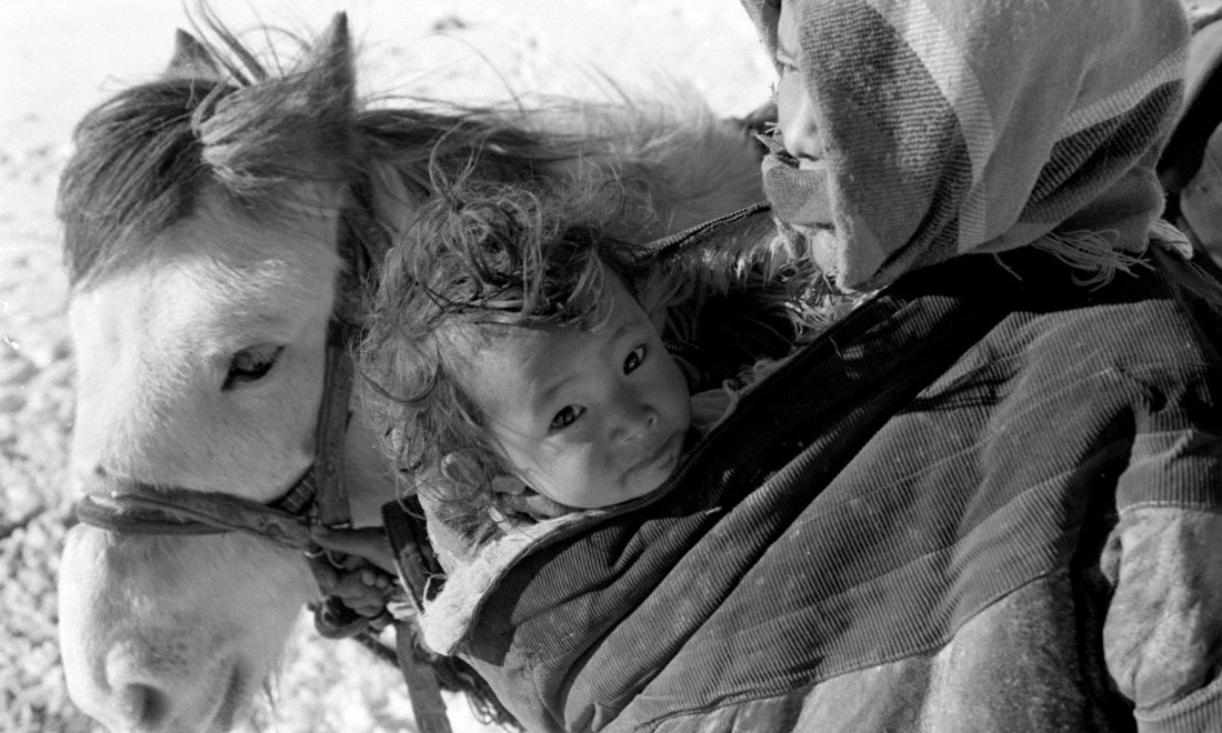 1990年3月，西藏當雄縣納木湖鄉(xiāng)三村女牧民斯卓不畏嚴寒，懷抱幼子，準備到遠處放牧。新華社記者覺果攝