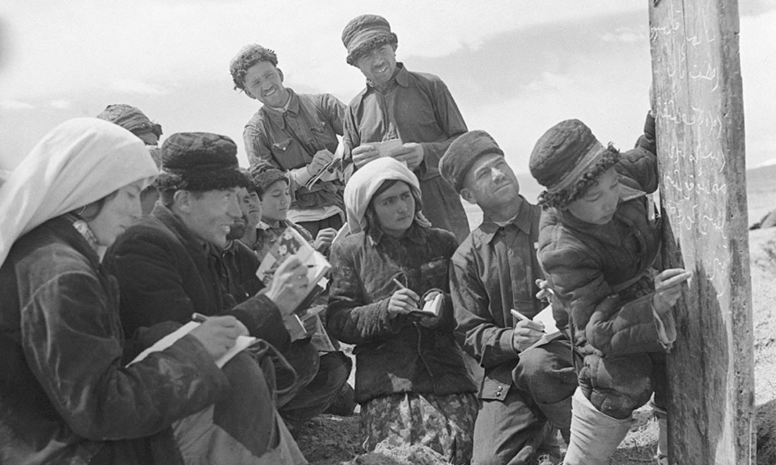 1960年6月，新疆慕士塔格峰下，大人們在小學生幫助下學習文化。新華社記者武純展攝