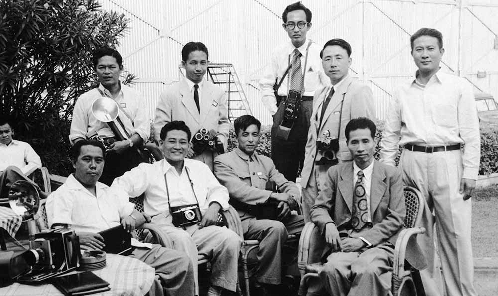 新華社記者錢嗣杰（站立者右二）在采訪會(huì)議開幕式后和外國記者在會(huì)場外休息。